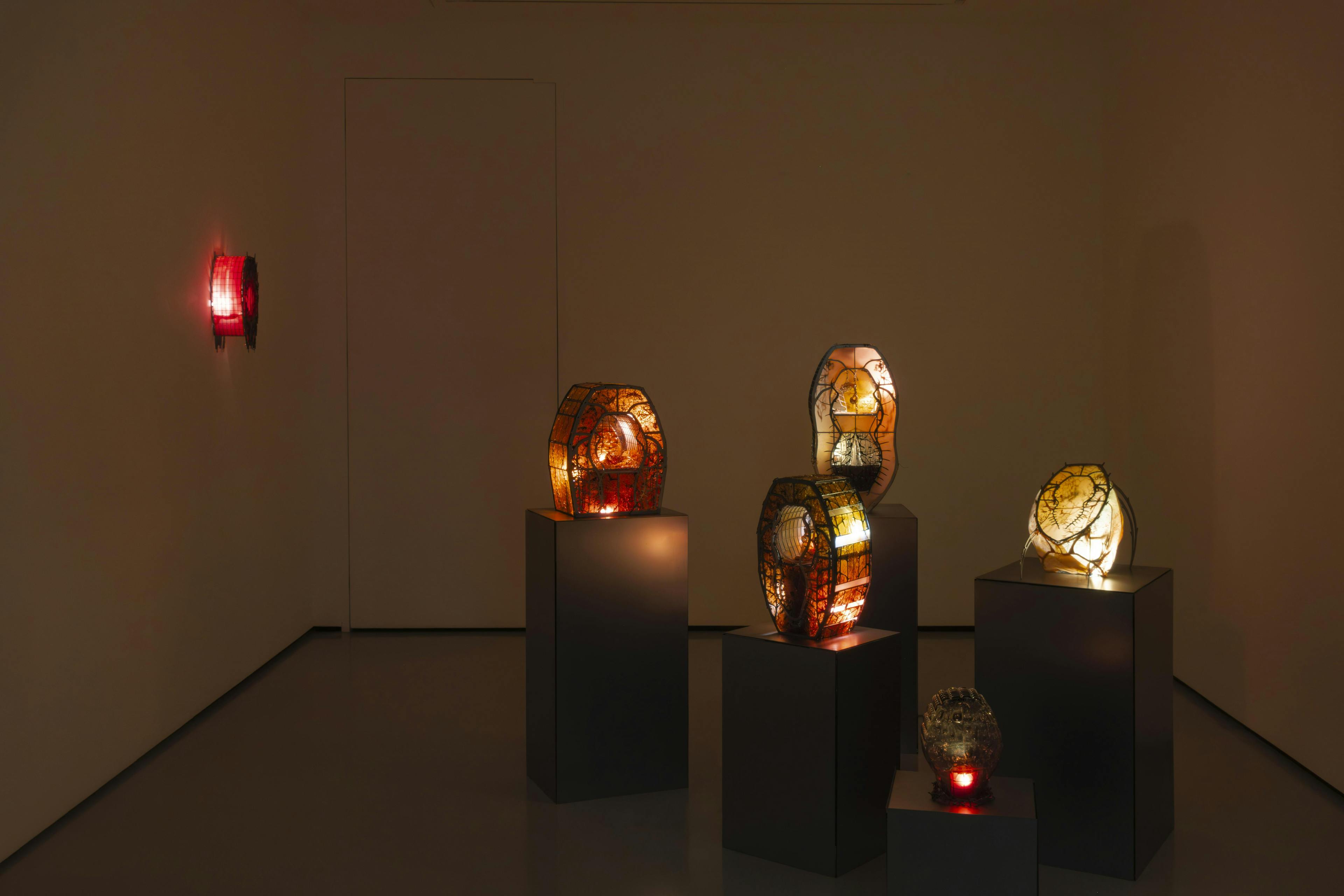 An installation view of Hazel Brill's exhibition featuring 5 glowing resin coloured sculptures on steel plinths