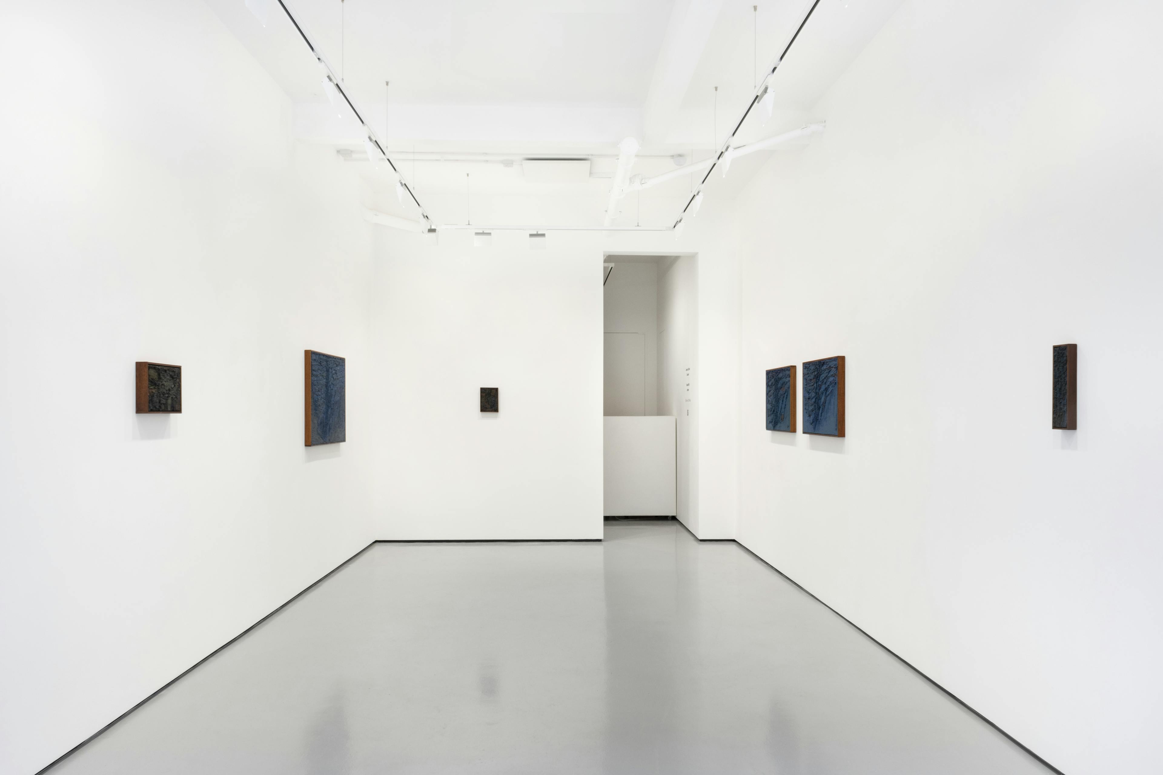 An installation image of James Collins solo exhibition in a white walled gallery space including 6 thick impasto paintings in dark wooden frames