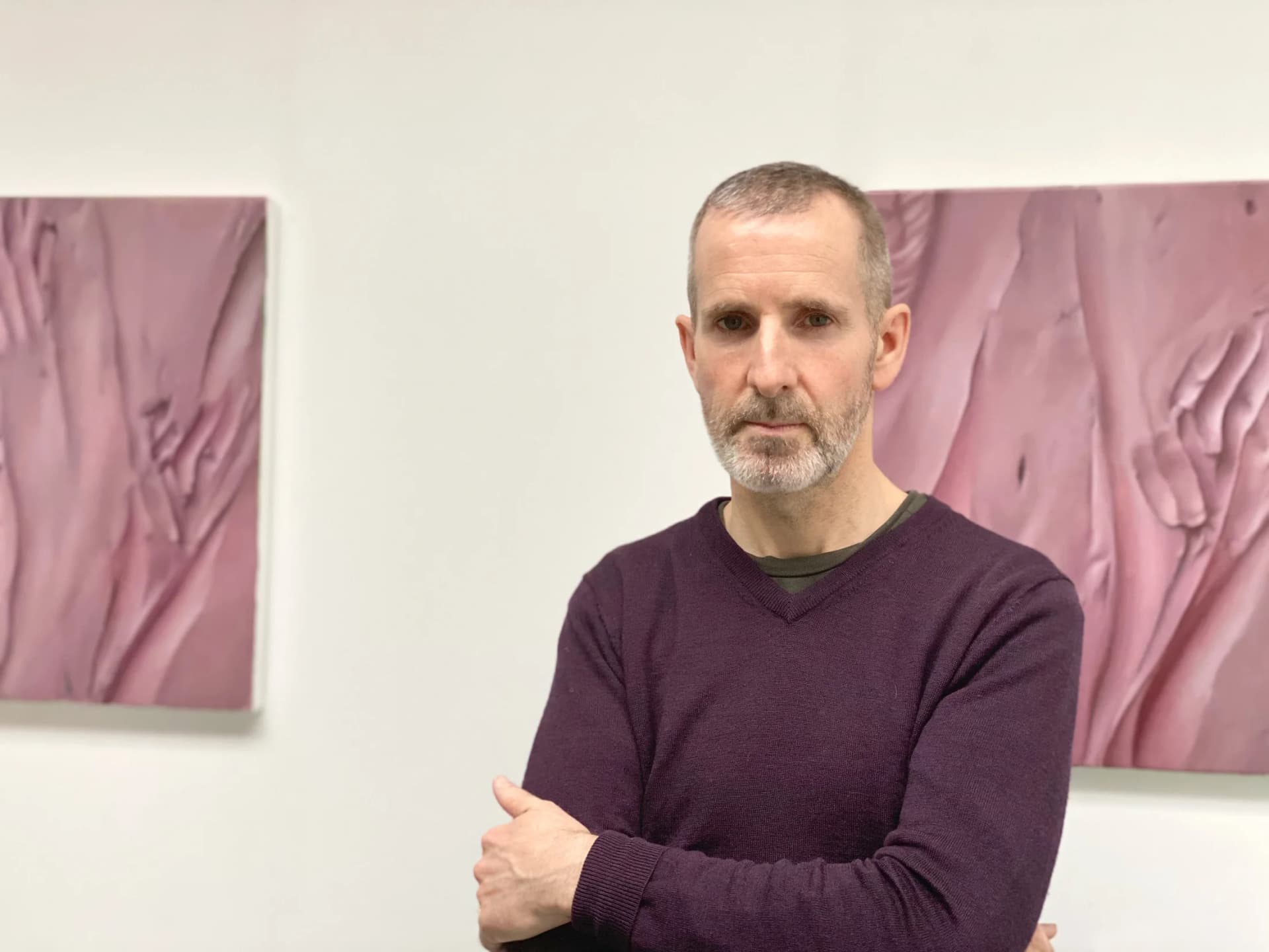 A portrait of Damien Meade stood in his studio